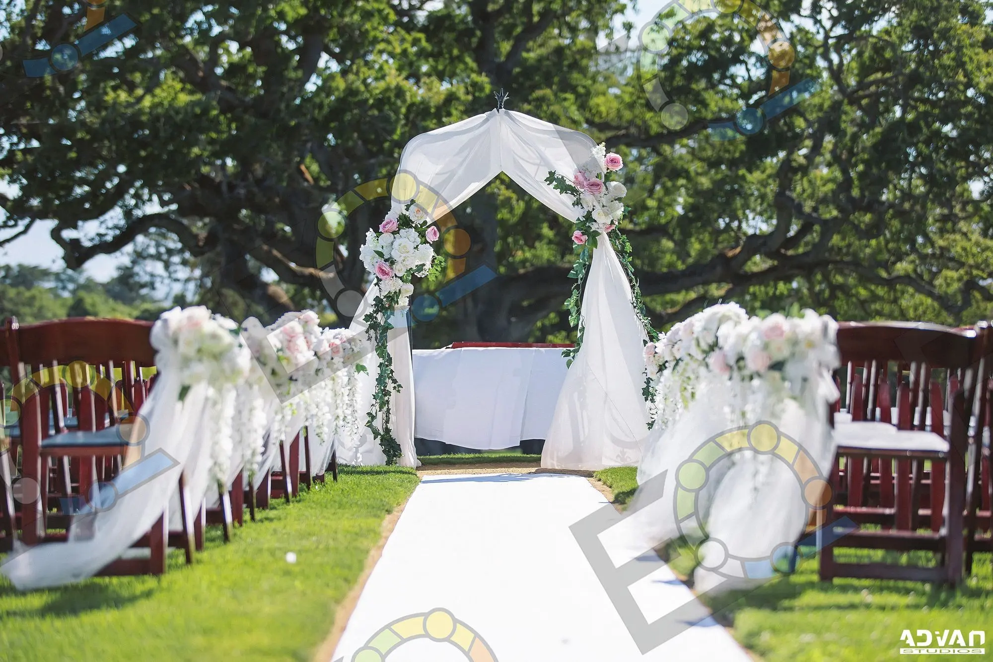 A white aisle leading to a draped floral ceremony arch