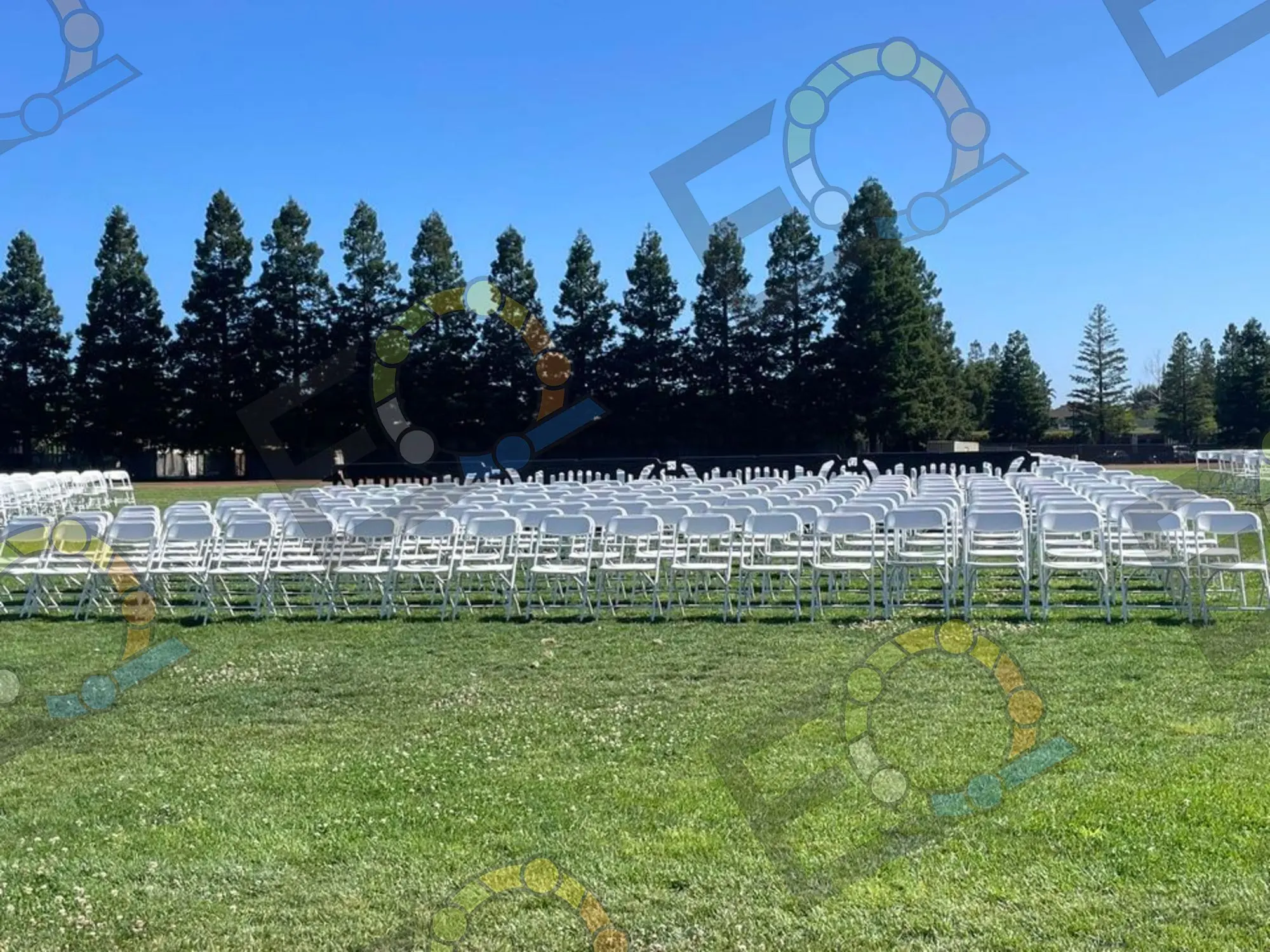 Patio tables in white linen under a pergola, set for an outdoor company event